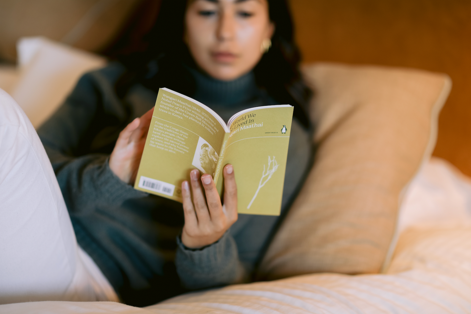 Woman reading a book, sat relaxed in bed.