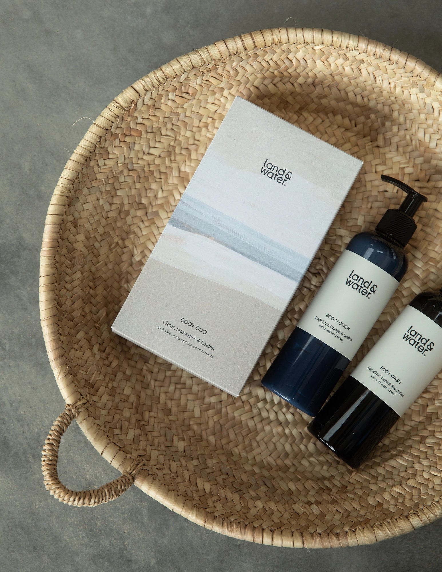 Body Wash bottle and Body Lotion bottle lying with gift box in a basket