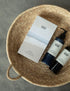 Body Wash bottle and Body Lotion bottle lying with gift box in a basket