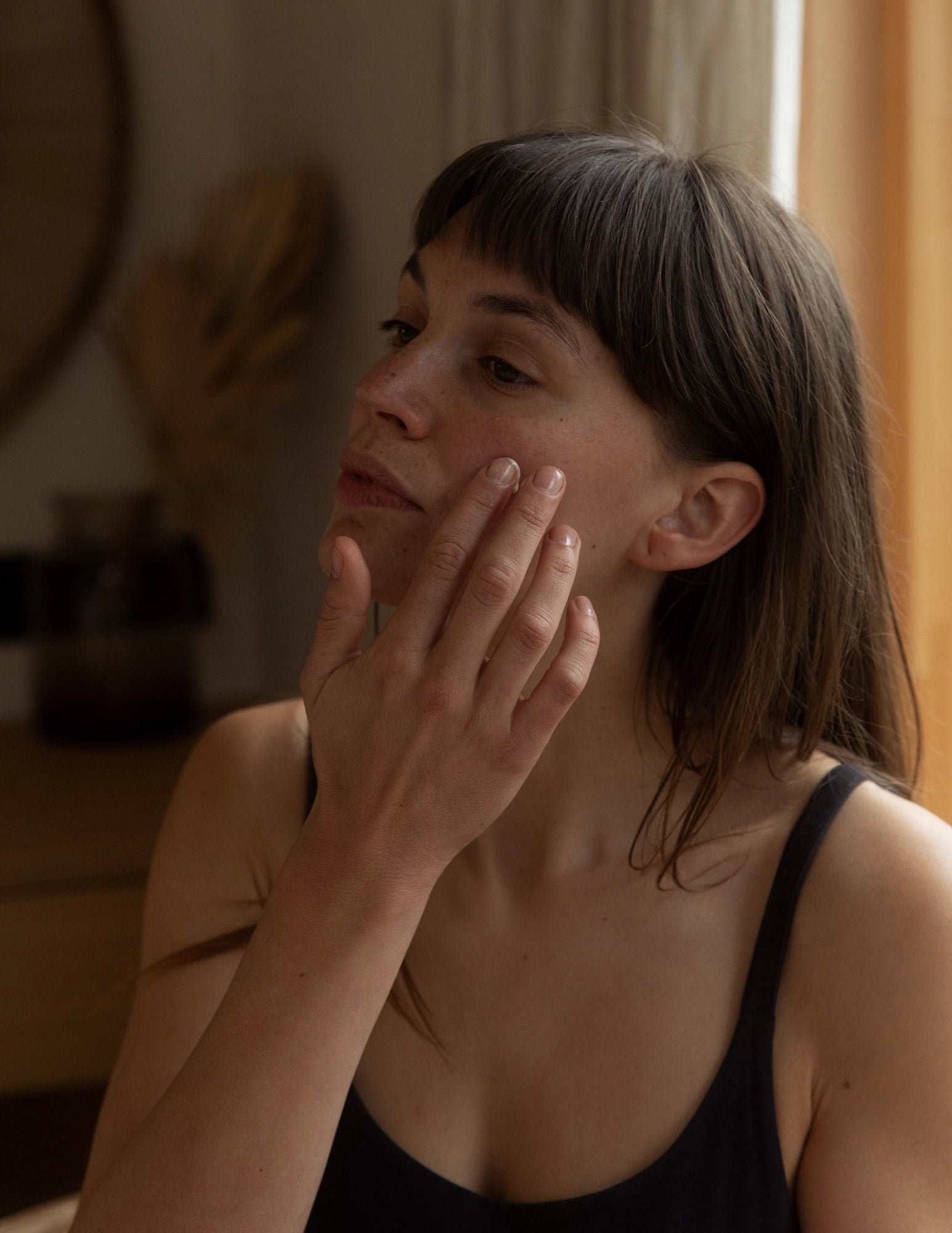 woman applying daily serum with fingertips