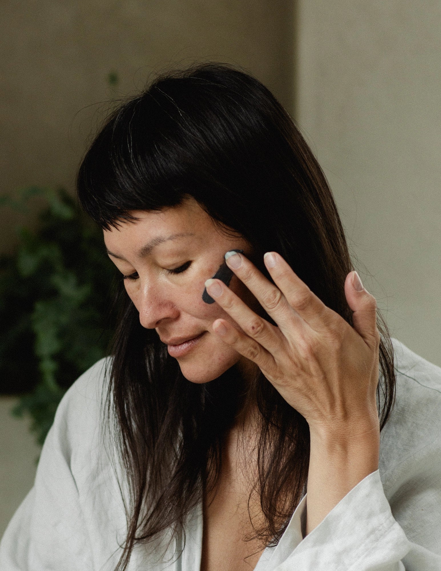 Woman applying Face Mask | Revive & Balance with fingers
