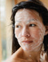 Woman with foaming face wash on her face