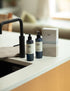 Hand Wash and Hand Lotion and gift box by a kitchen sink