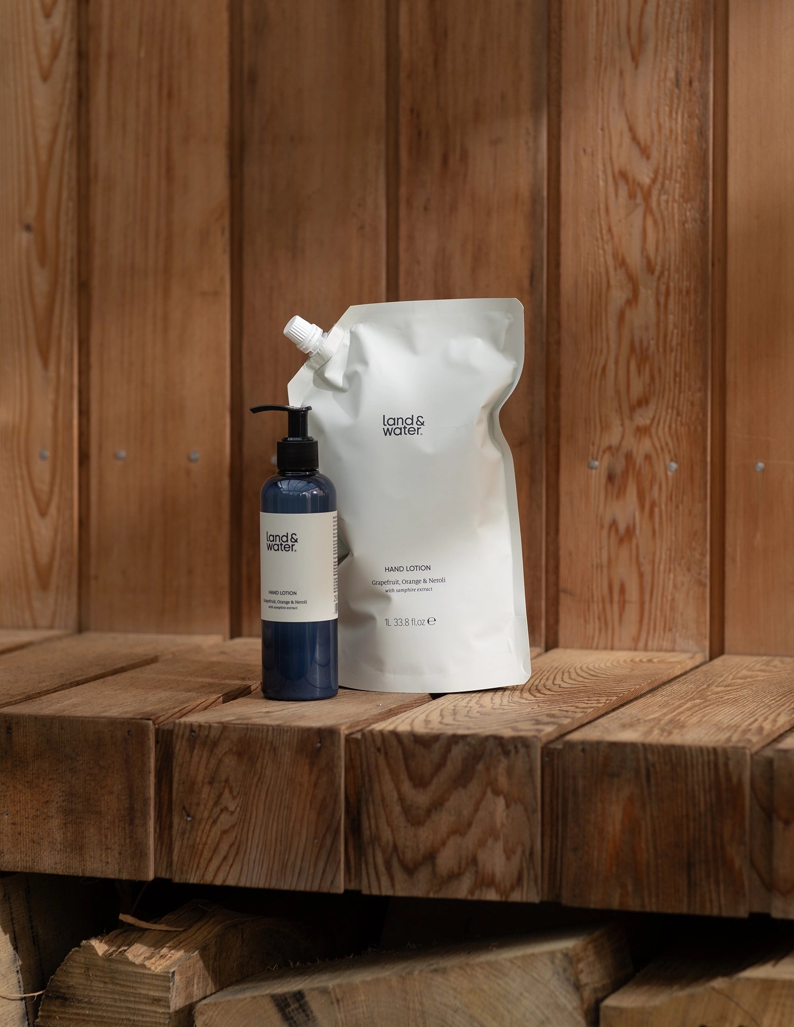 1 litre hand lotion refill pouch and 250ml body lotion bottle on wooden bench