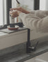 A short film clip of a woman wearing a soft oatmeal jumper, leaning over a kitchen sink washing her hands with land&water hand wash.