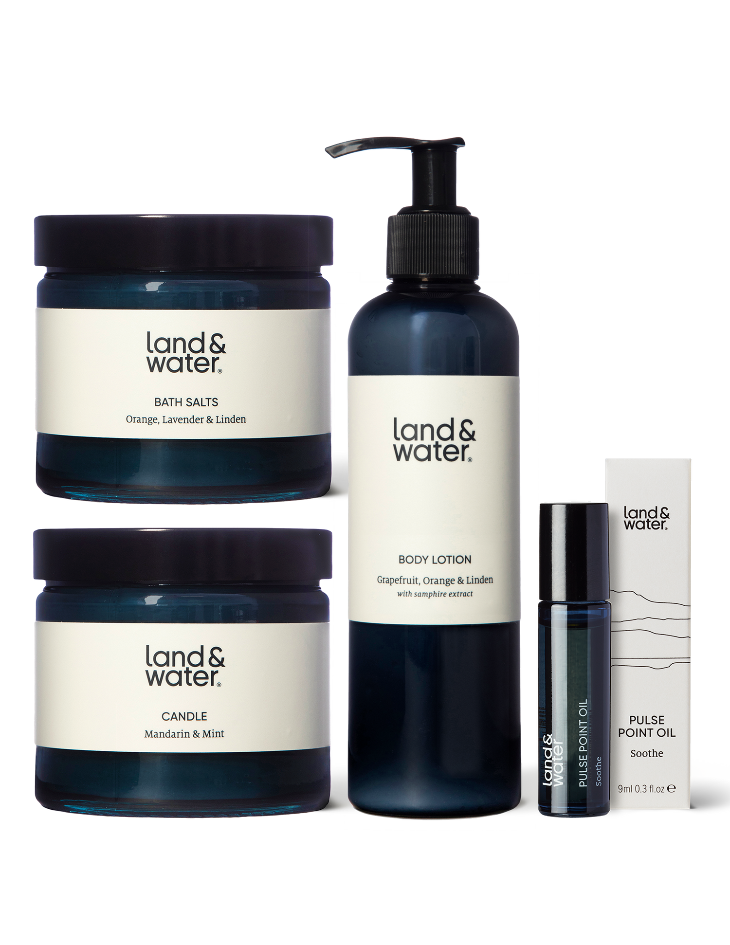 A collection of natural bath and body products including a candle, bath salts, pulse point oil, and body lotion.