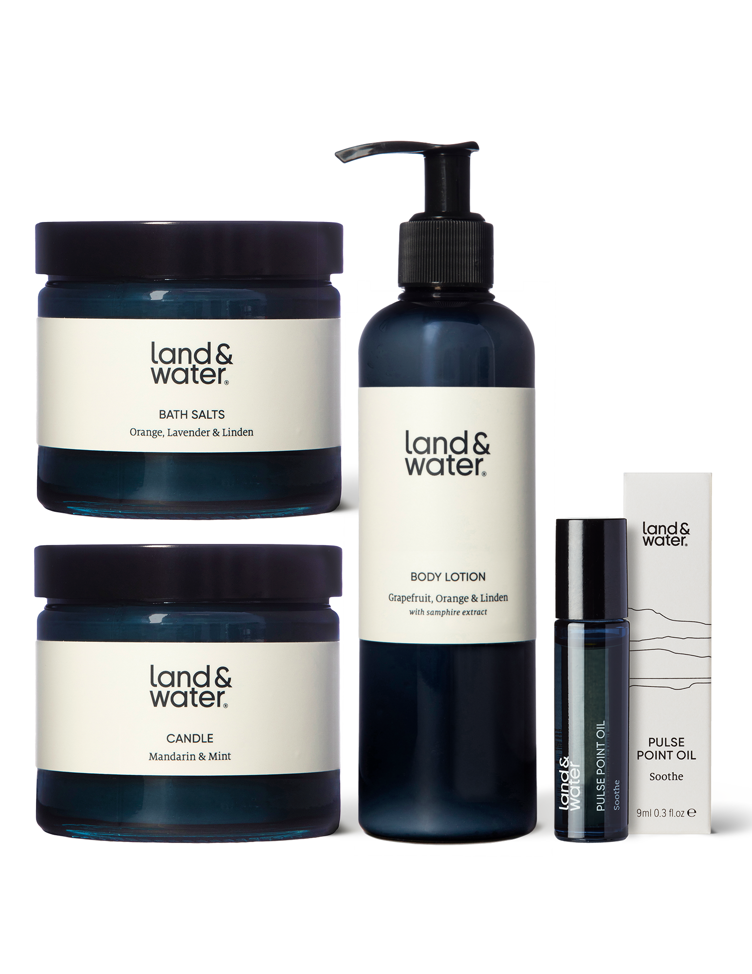 A collection of natural bath and body products including a candle, bath salts, pulse point oil, and body lotion.