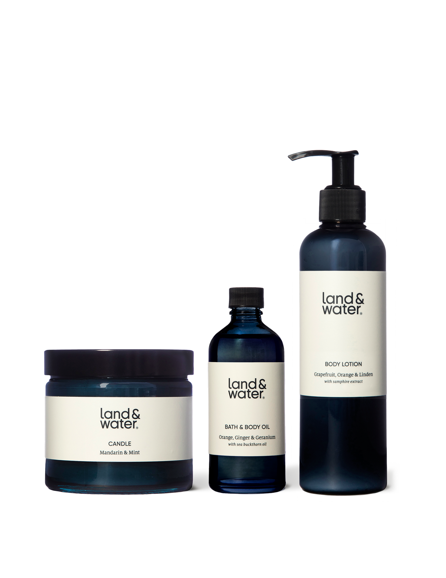 A Mandarin & Mint scented candle next to a bottle of bath and body oil and a body lotion. These items make up the &