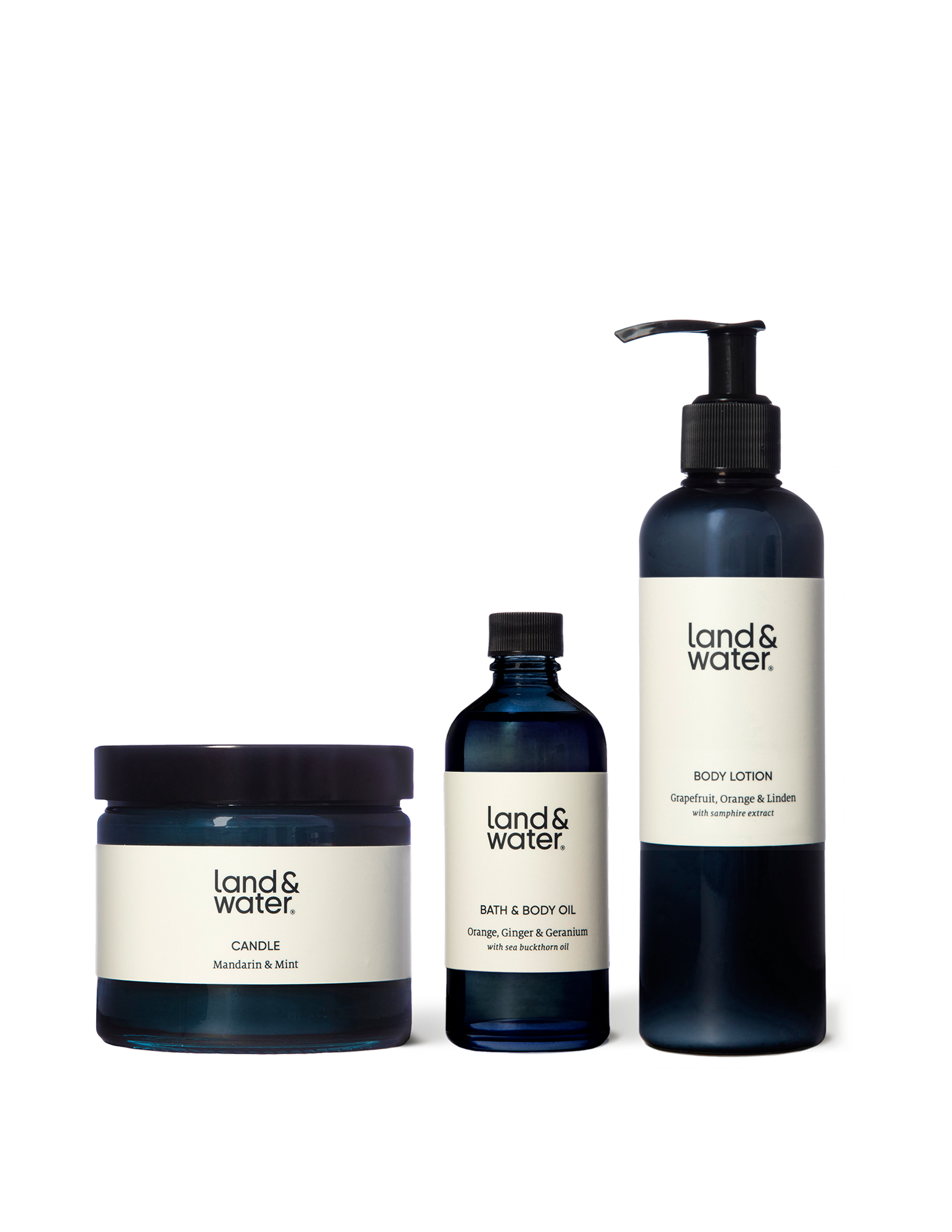 A Mandarin & Mint scented candle next to a bottle of bath and body oil and a body lotion. These items make up the &