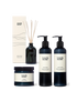 A collection of natural bath & body products; hand wash, hand lotion, a candle and reed diffuser.