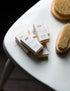 mini soap bars loosely stacked on a wooden chair alongside body brushes