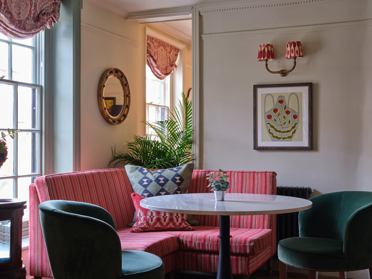 Bright coloured velvet sofas in living space at Stanwell House Hotel.