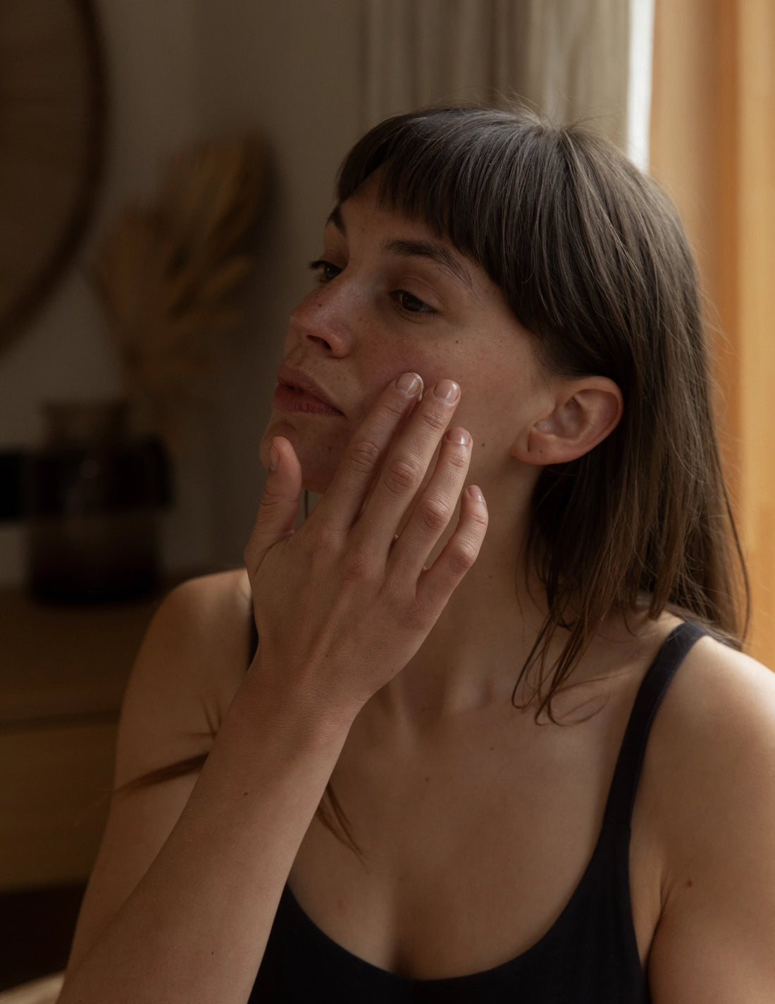woman applying daily serum with fingertips
