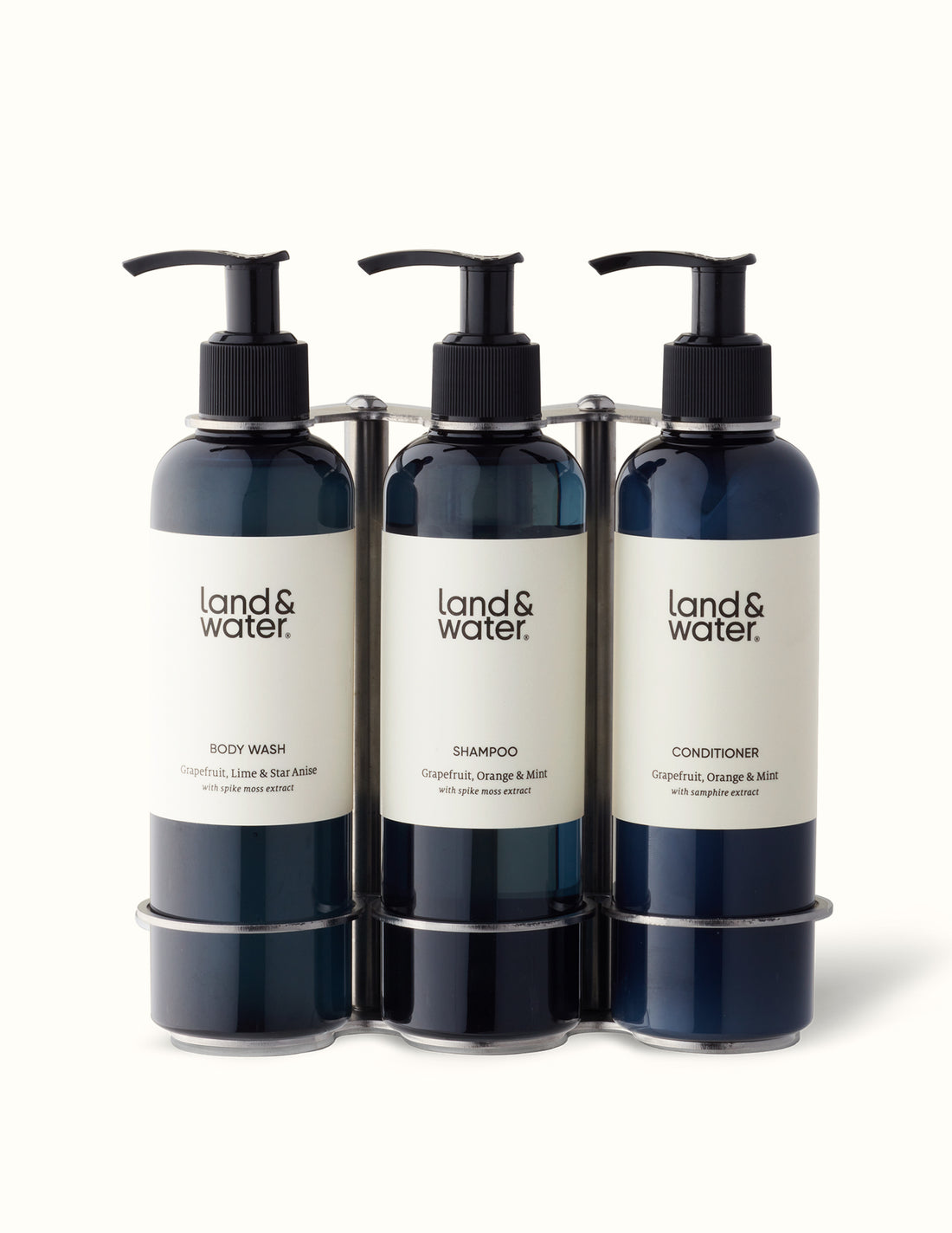 A brushed stainless steel triple wall bracket with three black pump bottles labeled &