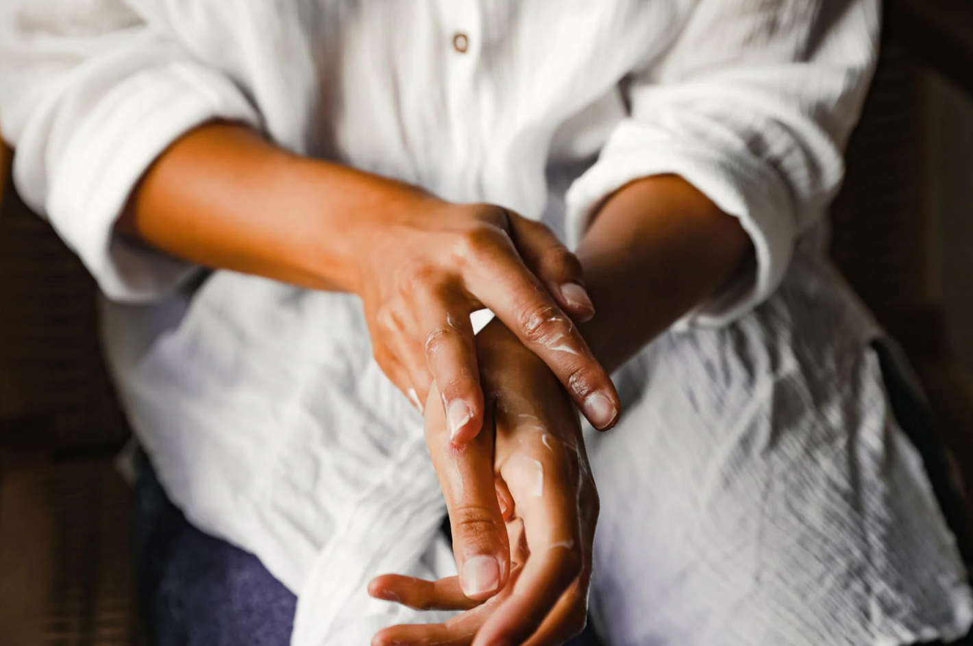 a person using land&water hand lotion on their hands