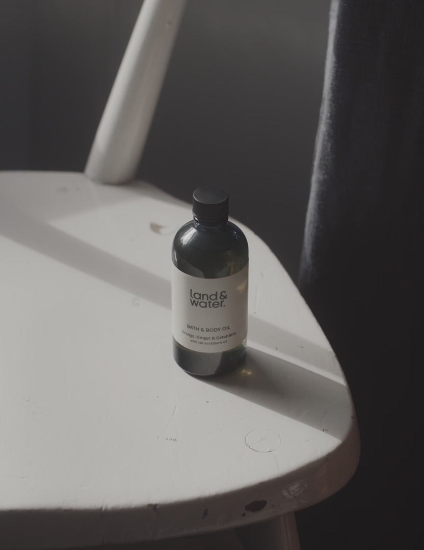 A short video clip of a bath and body oil bottle being picked up and poured into the palm of a woman&