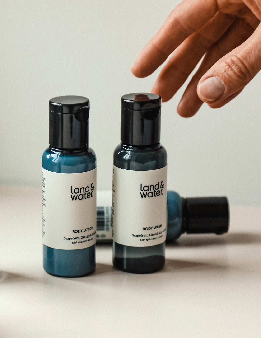 Two travel-sized bottles of body wash and lotion. A person&