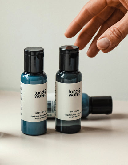 Two travel-sized bottles of body wash and lotion. A person&